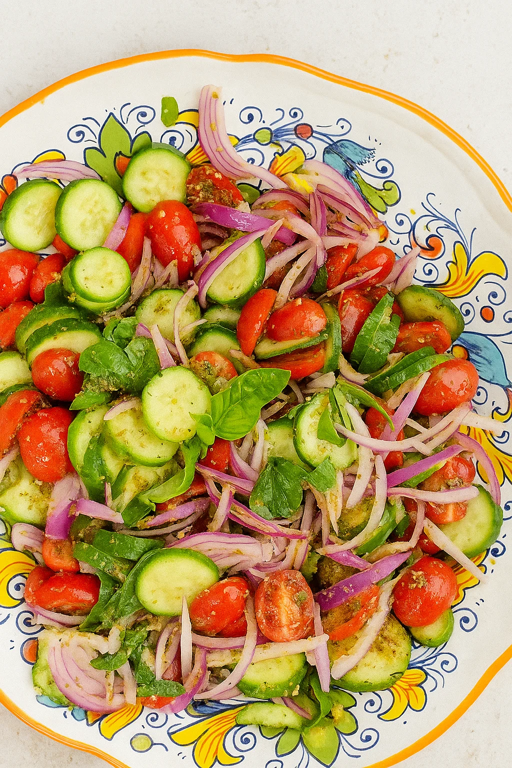 Fresh cucumber and tomato salad served on a plate with herbs