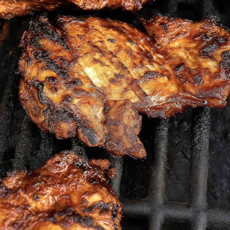 Close up of maple chipotle grilled chicken sizzling on the grill